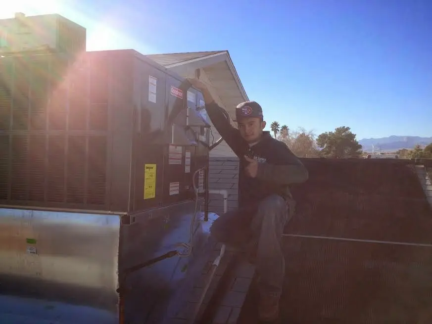 HVAC technician performing Boiler Repair on a rooftop unit in Texas